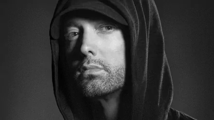HD PC desktop wallpaper featuring a close-up black-and-white portrait of Eminem wearing a hood, capturing his intense and contemplative expression in a music-themed design.