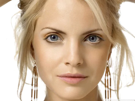 HD PC desktop wallpaper: close-up of a blonde woman with blue eyes and dangling earrings, neutral expression and soft, even lighting.