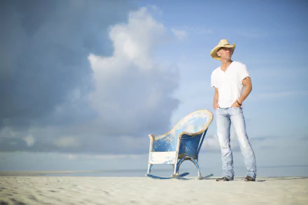HD desktop wallpaper of a person on a beach with a vintage chair, embodying a serene and contemplative mood.
