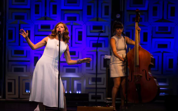 HD desktop wallpaper featuring two members of Lake Street Dive performing live on stage.