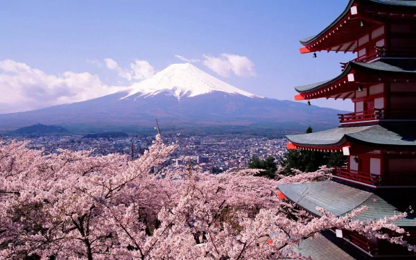 HD desktop wallpaper of Mount Fuji in Japan, featuring a traditional pagoda, cherry blossoms in the foreground, and the majestic snow-capped peak under a clear blue sky.