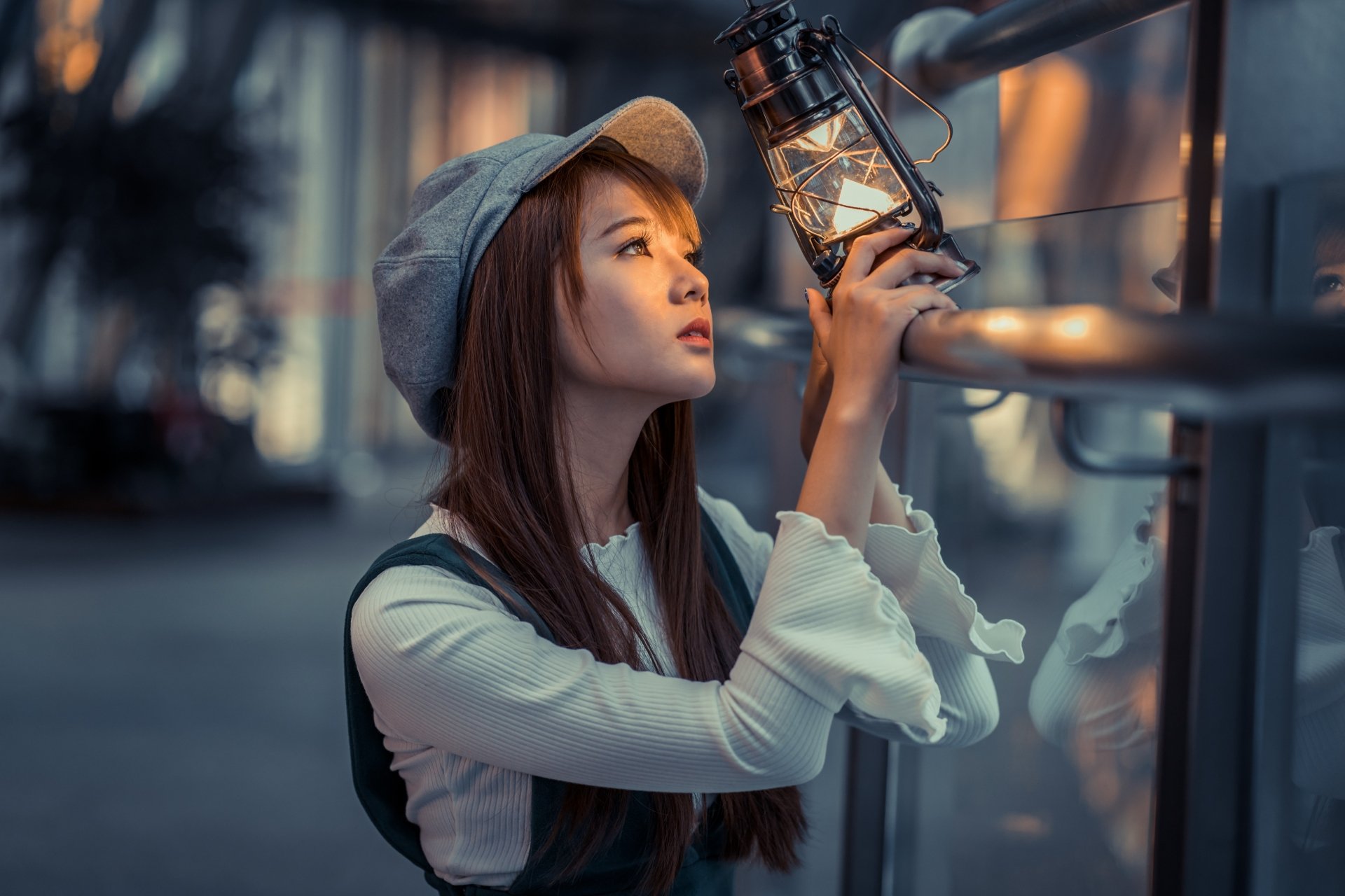 An HD desktop wallpaper featuring a brunette Asian woman wearing a hat, holding a lantern with a depth of field effect, creating a captivating and serene background.