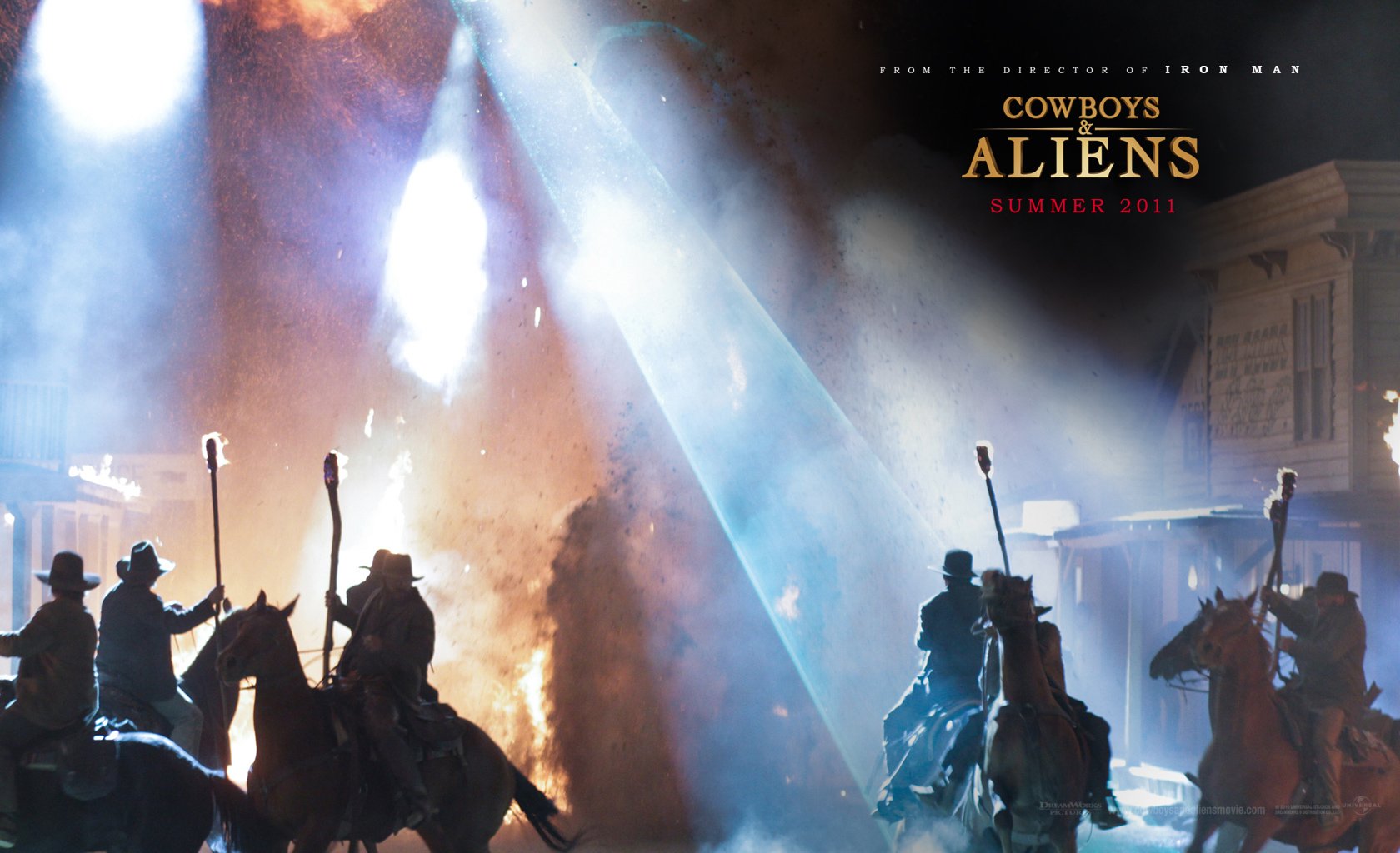 HD PC desktop wallpaper, Cowboys & Aliens: silhouetted cowboys on horseback raise rifles against blinding alien beams of light in a smoky, moonlit frontier town.