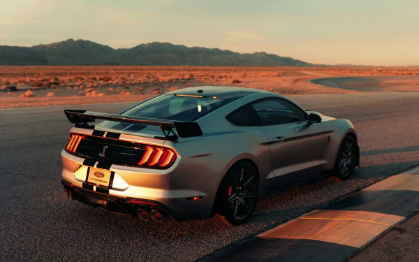 Silver Ford Mustang Shelby GT500 muscle car on a track at sunset, 4K Ultra HD desktop wallpaper background.
