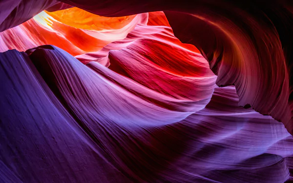 Vibrant 4K Ultra HD image of Antelope Canyon's smooth, flowing rock formations in vivid purple and orange hues, showcasing the beauty of nature's sculpted canyon walls.