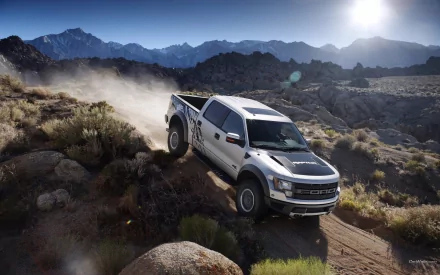 HD PC desktop wallpaper featuring a Ford Raptor vehicle driving off-road through a rugged mountainous landscape under a bright sun.