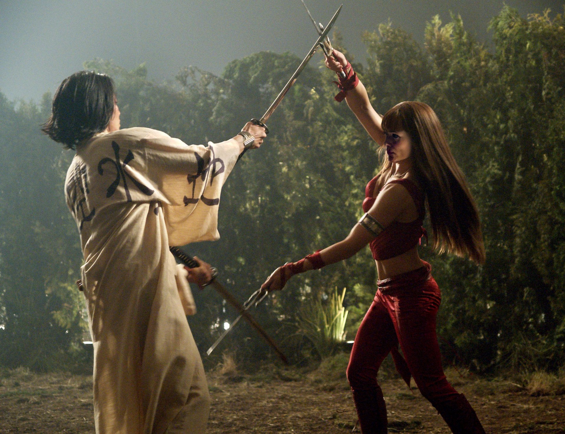 HD PC desktop wallpaper featuring a dynamic fight scene from the movie Elektra, showcasing two characters engaged in sword combat in a forest setting.