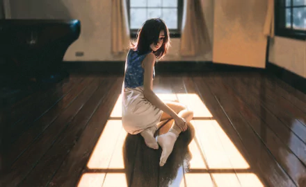 HD anime girl desktop wallpaper featuring a serene scene of a girl sitting on a sunlit wooden floor in a softly lit room.