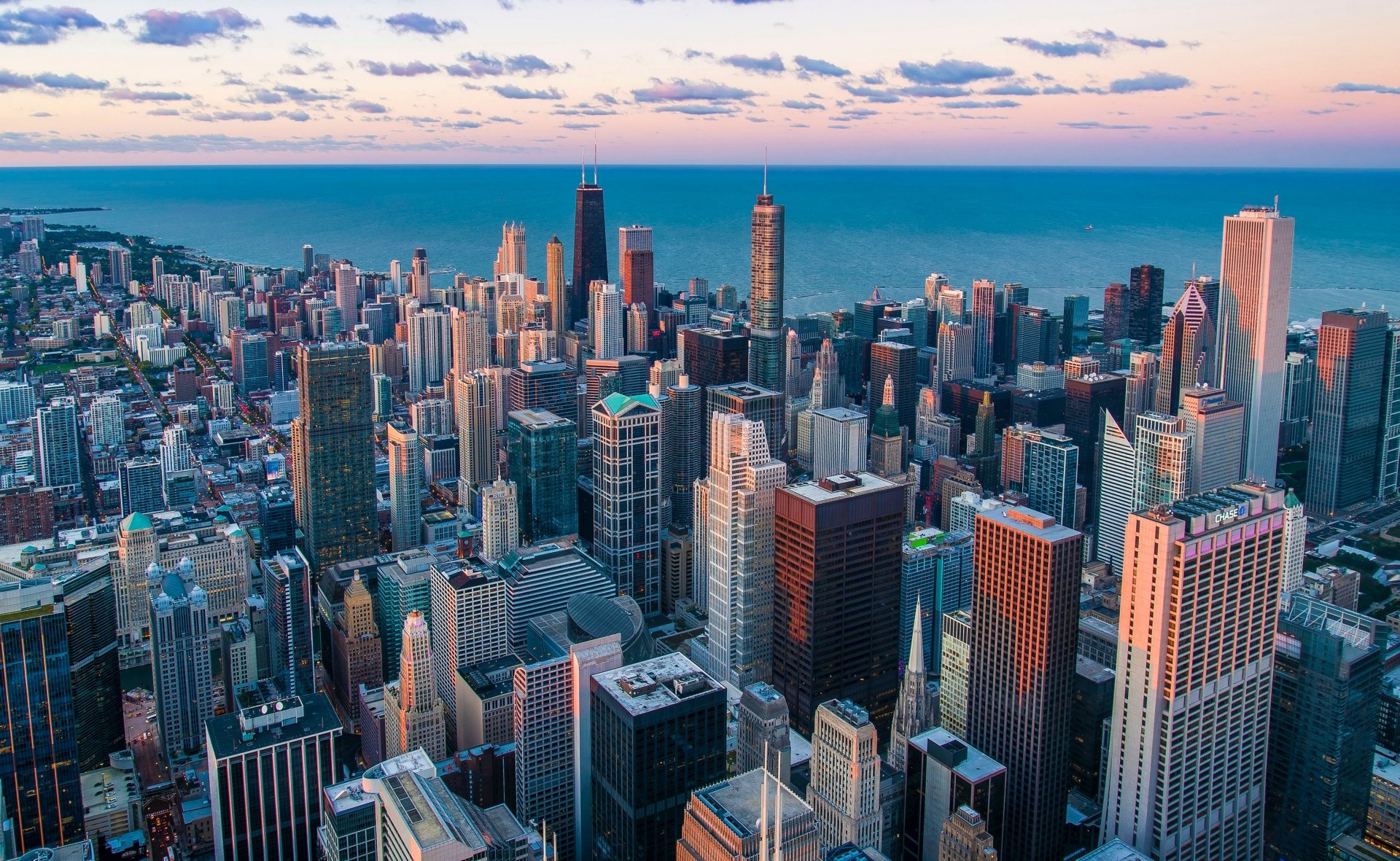 Aerial view of Chicago's skyscrapers along Lake Michigan at sunset, showcasing the city's iconic skyline and horizon in Michigan, USA.